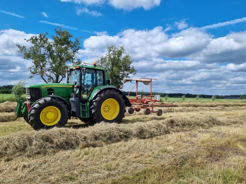 Chauffeur met trekker en werktuigen